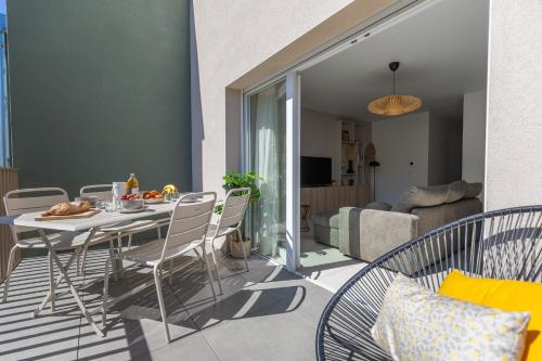 a dining table and chairs in a living room at "Lac'Almie" - Appartement 2 chambres avec Terrasse et Parking in Doussard