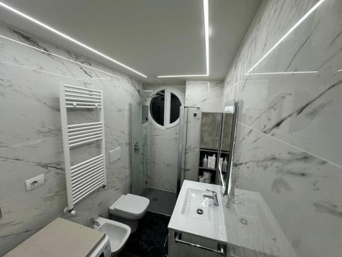 a white bathroom with a sink and a toilet at Appartamento Svetlana Segrate in Segrate