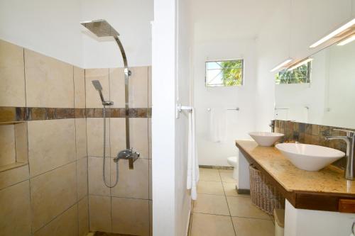 a bathroom with two sinks and a shower at Beach Escape in Trou d'Eau Douce