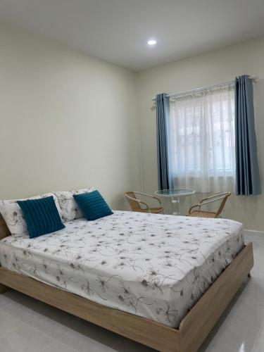 a bedroom with a bed with chairs and a glass table at 529 Cozy rooms in Ban Si Than