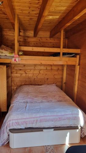 a bedroom with a bed in a log cabin at STUDIO indépendant dans un chalet traditionnel in Ban-sur-Meurthe-Clefcy