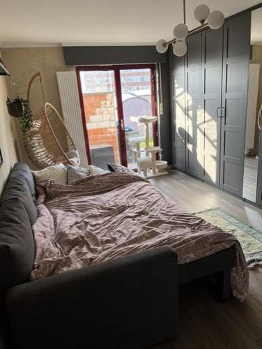 a bedroom with a bed and a sliding glass door at Room 1 km from tomorrowland in Boom