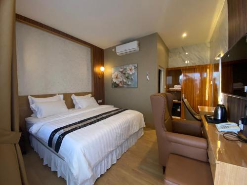 a hotel room with a large bed and a desk at Blessing Hotel Pandan in Halangan