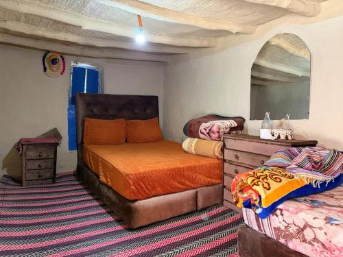 a bedroom with two beds and a mirror at Maison d'hôte Yeswal in Guezira