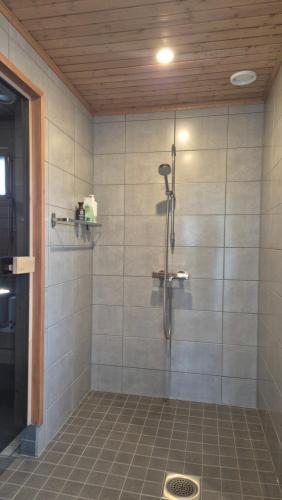 a shower in a bathroom with a tile floor at Saunatupa Kajaani in Kajaani