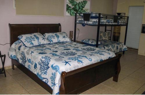 a bedroom with a bed with a blue and white comforter at Eden's Garden in Isabela