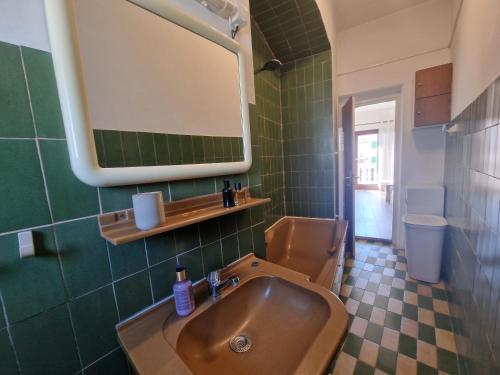 a bathroom with a sink and a toilet and a mirror at Ivory Apartment in Biograd na Moru