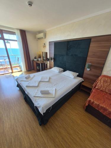 a large bedroom with a large bed and a balcony at Guest Rooms Skalite in Sozopol
