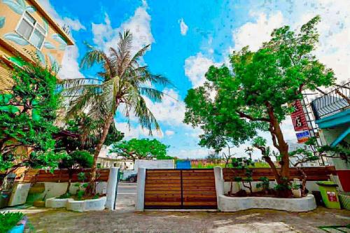a fence with trees in front of a building at Fumigate Hotel in Hengchun South Gate