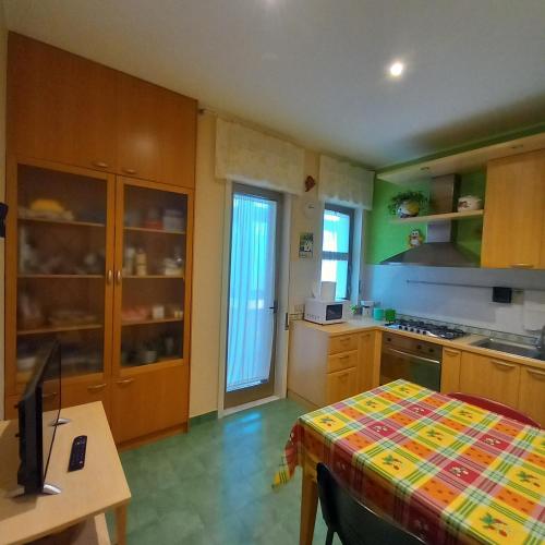 a kitchen with wooden cabinets and a table with a desk at New Magnolia House in Belpasso