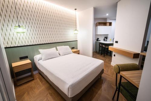 a small bedroom with a bed and a kitchen at OIKOS APARTAMENTOS TURÍSTICOS in Monesterio
