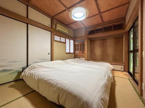 a bedroom with a large bed in a room with windows at 2nd Home Kaminagayoshi in Ichihara