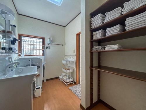 a bathroom with a sink and a shelf with dishes at 2nd Home Kaminagayoshi in Ichihara