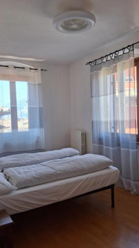 a bedroom with two beds and a window at la terrazza del borgo con parcheggio in Malcesine