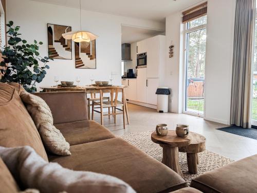a living room with a couch and a table at Wellness Chalet Hellendoorn met Hot tub en Sauna in Haarle