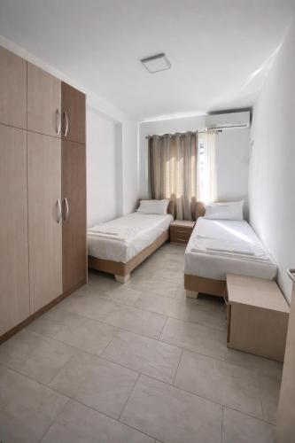 a large room with two beds and a cabinet at Mare Nostrum Residence in Shëngjin