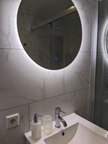 a bathroom with a sink and a mirror at Wellness Chalet Hellendoorn met Hot tub en Sauna in Haarle