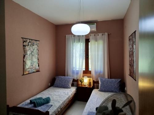a bedroom with two beds and a window at Sunshine in Olympiada