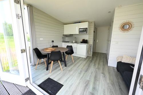 a small kitchen and dining room with a table and chairs at Chalet Zijdewind in Zijdewind