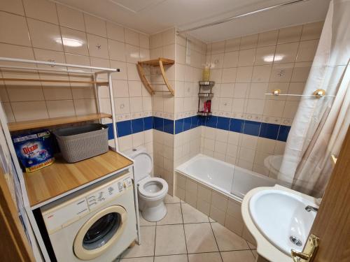 a bathroom with a sink and a toilet and a tub at Caparica City & Beach in Caparica
