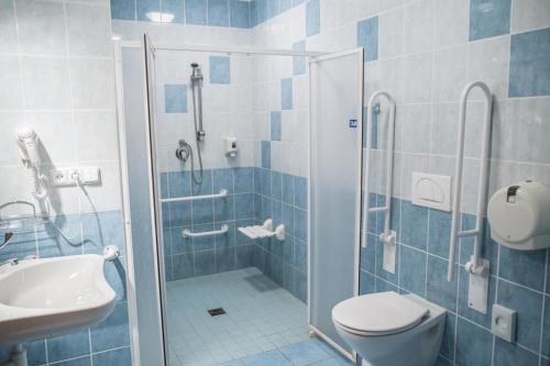 a bathroom with a shower and a toilet and a sink at Hotel Na Jižní in Přerov