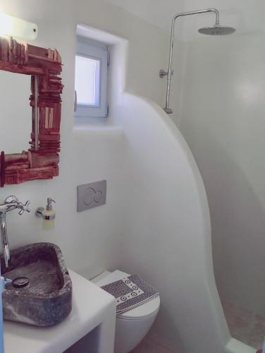 a white bathroom with a sink and a toilet at Palio Karnagio Παλιό Καρνάγιο in Koufonisia