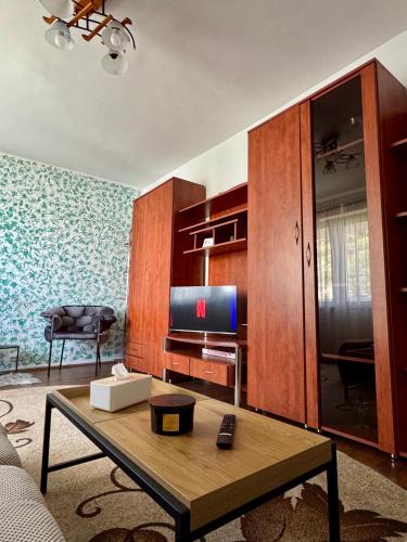 a living room with a tv and a coffee table at Your cozy place in Târgu-Mureş