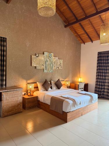 a bedroom with a large bed with two tables and lamps at Aayu Lagoon in Negombo