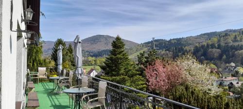 a balcony with tables and chairs and mountains at Na Markówce in Brenna