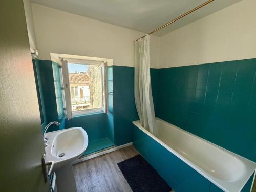a bathroom with a sink and a toilet and a tub at Appartement VAIS in Cognac