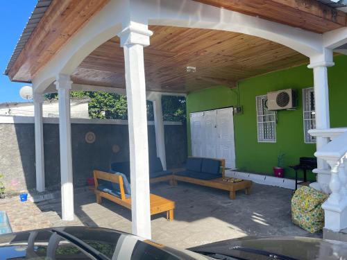 a covered patio with two chairs and a table at Amalis in Moroni