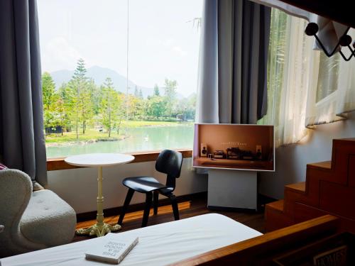 a room with a large window with a view of a lake at Villa At On Organic Farm in Ban Wak