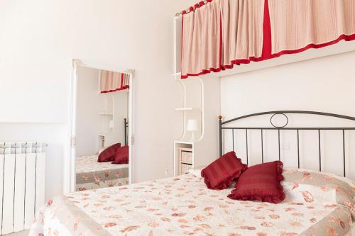 a bedroom with a bed with red pillows on it at Nice villa only 100m from the beach in Fregene