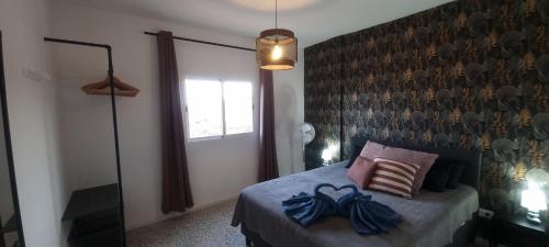 a bedroom with a bed with blue bows on it at Kamer Appartement in Arico in La Sabinita