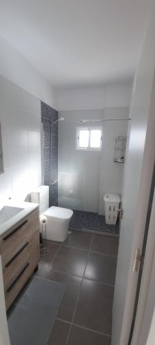 a white bathroom with a toilet and a sink at Kamer Appartement in Arico in La Sabinita