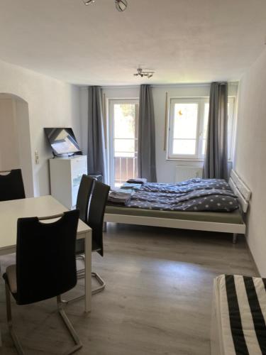 a bedroom with a bed and a table and chairs at Am Wald, Am Berg in Unterreichenbach