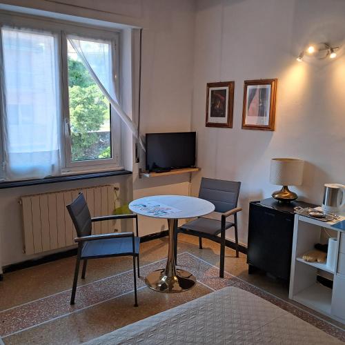 a living room with a table and chairs and a tv at Sportrek House in Levanto