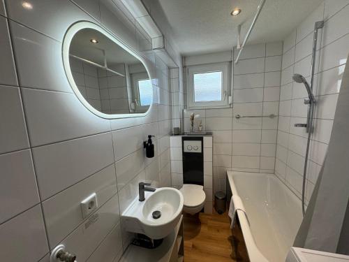 a bathroom with a sink and a toilet and a tub at Apartment SeeZeit - Top Lage & nahe am Bodensee in Friedrichshafen