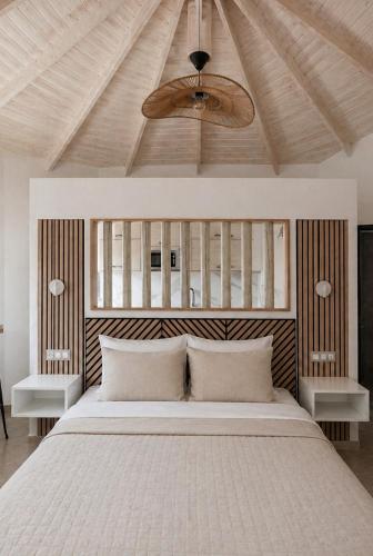 a bedroom with a large white bed and a ceiling at Lux Studios With Private Pool by ILIOS Georgioupoli in Georgioupoli