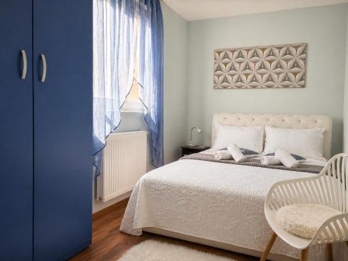 a bedroom with a bed and a window and a chair at Apartman i sobe Milica Vrnjacka Banja in Vrnjci