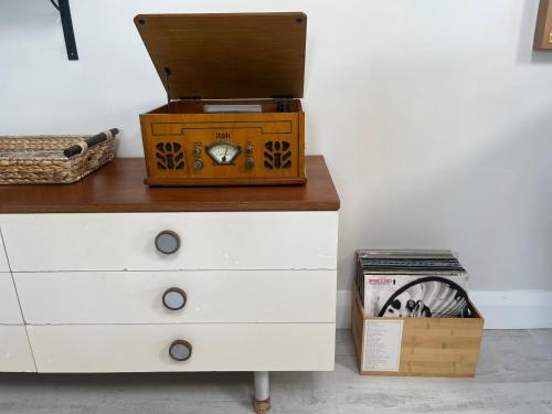 a dresser with a clock and a box on top of it at Harbour view retreat Cró na mbó in Midleton