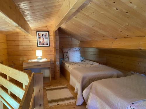 a bedroom with two beds in a log cabin at Domek pod Świerkiem in Wapnica