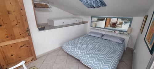 a small bedroom with a bed and a mirror at Abbronzatissima Capo d'Orlando in Capo dʼOrlando