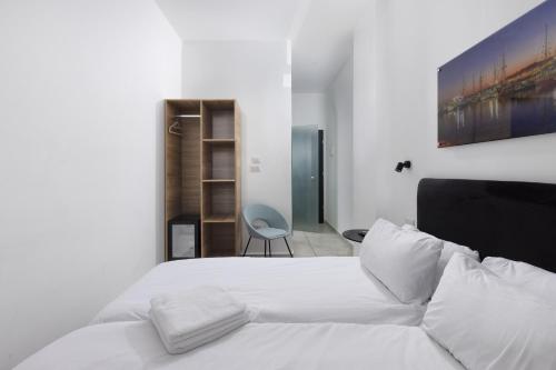 a bedroom with a white bed and a chair at Razin 37 in Eilat