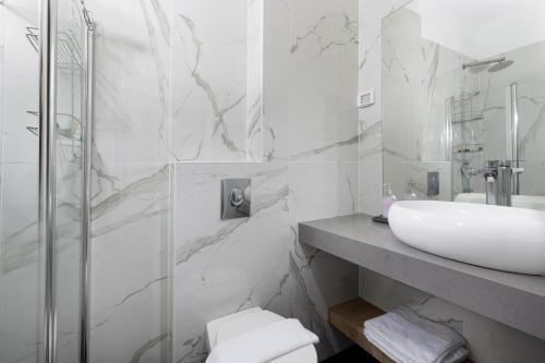 a white bathroom with a sink and a shower at Razin 37 in Eilat