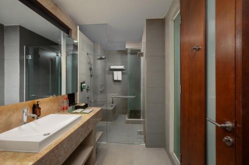 a bathroom with a sink and a shower at Amandaru Hotel Pekalongan in Pekalongan