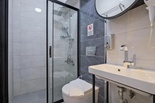 a bathroom with a shower and a toilet and a sink at Miralya Rooms in Fethiye