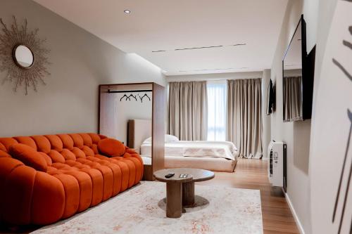 a bedroom with an orange couch and a bed at Agate Hotel Tirana in Tirana