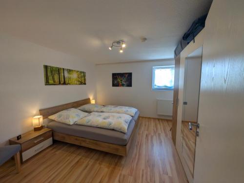 a bedroom with a bed and a window and a door at Ferienwohnung 's Stüble in Schönwald