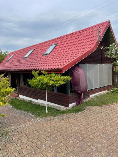 a red roofed house with a red roof at Marokanski domek in Mielnik